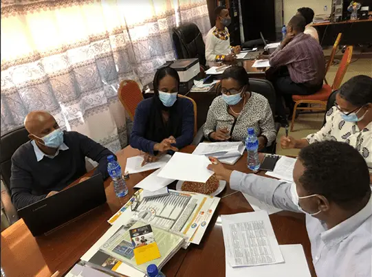 A meeting at the school, people sitting around a table with lots of documents